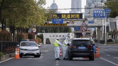 Traffic police wearing protective suits check on a vehicle before an underpass tunnel which has closed following the coronavirus outbreak in Shanghai, China, on Monday. (AP) Traffic police wearing protective suits check on a vehicle before an underpass tunnel which has closed following the coronavirus outbreak in Shanghai, China, on Monday. (AP)