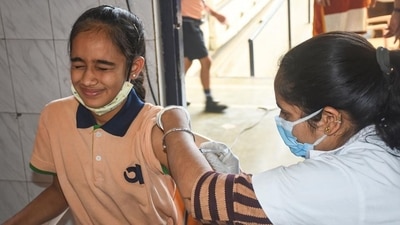 A health worker administers a dose of Covid-19 vaccine to a student in Surat. (PTI) A health worker administers a dose of Covid-19 vaccine to a student in Surat. (PTI)