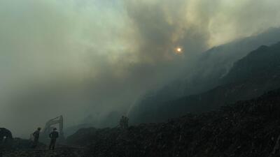 Firefighters spray water to distinguish the fire and to clear the smoke at Ghazipur garbage landfill in New Delhi on Monday. (Raj K Raj/HT Photo)