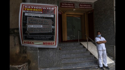 A man wearing mask stand outside a bank on the first day of a two-day nationwide strike in Mumbai, March 28, 2022 (AP) A man wearing mask stand outside a bank on the first day of a two-day nationwide strike in Mumbai, March 28, 2022 (AP)
