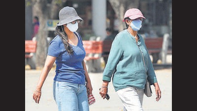 Shoppers shielding themselves with hats and sunglasses to beat the searing heat at the Sector 17 Plaza on Monday afternoon. (Keshav SIngh/HT)