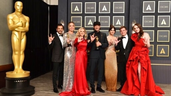 Eugenio Derbez, from left, Sian Heder, Marlee Matlin, Troy Kotsur, Emilia Jones, Daniel Durant, and Amy Forsyth, winners of the award for best picture for CODA pose in the press room while signing "I love you" at the Oscars. (AP)