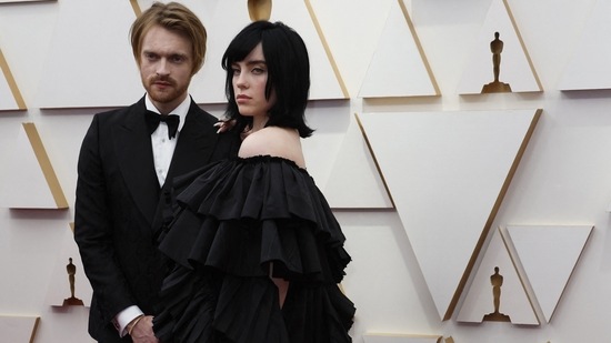 Billie Eilish and her brother Finneas O'Connell won the original-song Oscar for No Time to Die, the title tune for the latest James Bond film, at Sunday's 94th annual Academy Awards. The singer wore a dramatic black Gucci gown decorated with row upon row of ruffles. Finneas accompanied his sister in a black tuxedo.