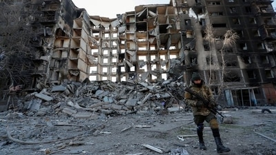 A service member of pro-Russian troops walks near an apartment building destroyed in the course of Ukraine-Russia conflict in the besieged southern port city of Mariupol, Ukraine. (REUTERS)