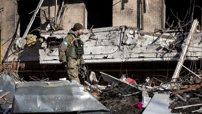 A Ukraine soldier inspects the rubble of a destroyed apartment building in Kyiv on March 15, 2022. (Photo by FADEL SENNA / AFP) (AFP) A Ukraine soldier inspects the rubble of a destroyed apartment building in Kyiv on March 15, 2022. (Photo by FADEL SENNA / AFP) (AFP)