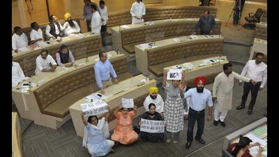 AAP councillors demanding a debate on the water tariff hike issue in the well of the MC House during a meeting in Chandigarh on Tuesday. (Keshav Singh/HT) AAP councillors demanding a debate on the water tariff hike issue in the well of the MC House during a meeting in Chandigarh on Tuesday. (Keshav Singh/HT)