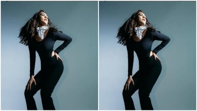 Mrunal paired a full-sleeved black top with cut-out details near to the side of the waist with a pair of black trousers with wide legs. (Instagram/@mrunalthakur)