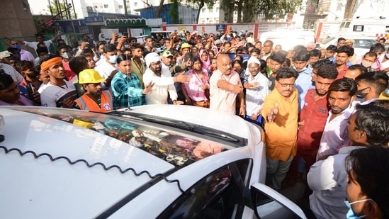 People protesting in front of the municipal commissioner’s vehicle after two workers of a private agency hired by Jal Sansthan died while cleaning a septic tank in Saadatganj area of Lucknow on Tuesday. (Deepak Gupta/HT Photo)