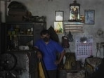 A Sri Lankan workshop owner pauses his work and waits during a power cut in Wattala, a suburb of Colombo (AP)