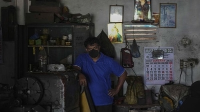 A Sri Lankan workshop owner pauses his work and waits during a power cut in Wattala, a suburb of Colombo (AP) A Sri Lankan workshop owner pauses his work and waits during a power cut in Wattala, a suburb of Colombo (AP)