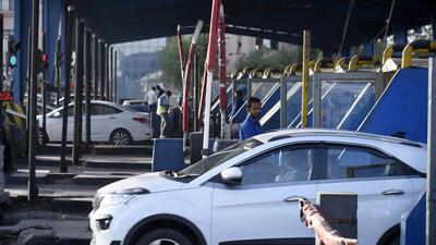 A man collecting toll tax from a commuter at the Kherki Daula toll plaza in Gurugram on Wednesday. (Parveen Kumar/HT photo)