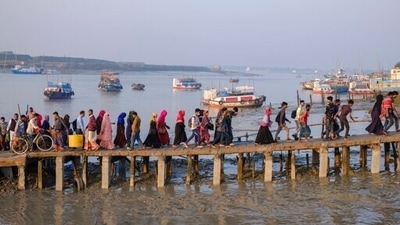 Workers walk to work at an export processing zone early in the morning after crossing the Mongla river in Mongla, Bangladesh. This Bangladeshi town stands alone to offer new life to thousands of climate migrants. (AP Photo/Mahmud Hossain Opu) (AP)