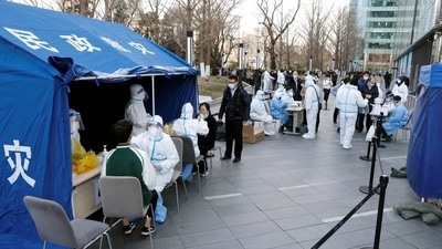 People line up during a mass testing for the coronavirus disease (Covid-19) at a makeshift nucleic acid testing site outside a shopping mall in Beijing, China. (REUTERS)