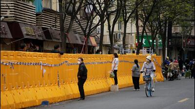 Food vendors stand behind barricades of a sealed-off area, following the coronavirus disease (Covid-19) outbreak in Shanghai, China. (REUTERS)
