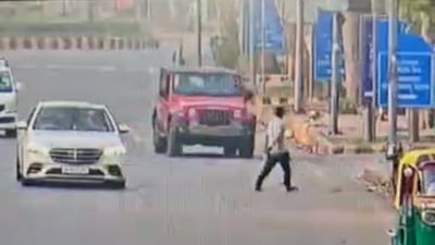 The footage of the incident, captured by a CCTV camera installed near the spot, showed a red Thar SUV moving straight on the road, when it suddenly changed direction and headed straight towards Girdhari, who is seen crossing the road and making for the footpath. (Sourced) The footage of the incident, captured by a CCTV camera installed near the spot, showed a red Thar SUV moving straight on the road, when it suddenly changed direction and headed straight towards Girdhari, who is seen crossing the road and making for the footpath. (Sourced)