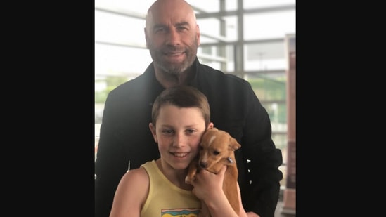 The image, taken from Instagram shows John Travolta and his son with the dog from Betty White’s tribute at Oscars. (Instagram/@johntravolta)