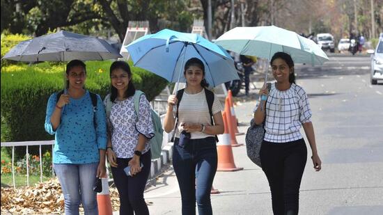 Students using umbrellas to shield themselves from the scorching heat at Panjab University in Chandigarh. (Keshav Singh/HT)