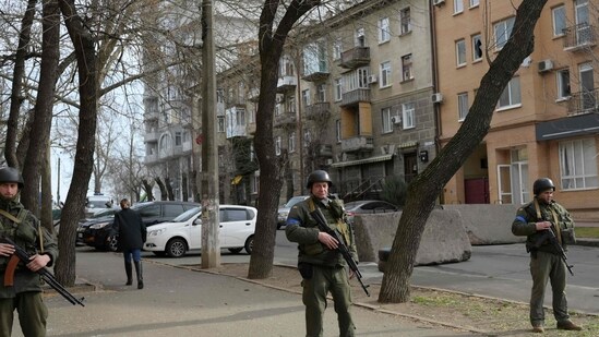 Soldiers stand guard outside a government building hit by Russian rockets on March 29, 2022.(AFP)