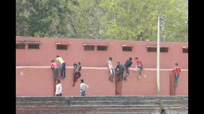 Friends and relatives of Class 10 students enrolled under the BSEH were found climbing walls and throwing answer cheat-sheets at Government Model School exam centre in Rohtak’s Sanghi village on Thursday. (Manoj Dhaka/HT) Friends and relatives of Class 10 students enrolled under the BSEH were found climbing walls and throwing answer cheat-sheets at Government Model School exam centre in Rohtak’s Sanghi village on Thursday. (Manoj Dhaka/HT)