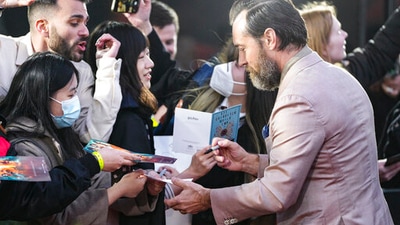 Jude Law signs autographs upon arrival at the world premiere of the film Fantastic Beasts: The Secrets of Dumbledore in London Tuesday. (AP) Jude Law signs autographs upon arrival at the world premiere of the film Fantastic Beasts: The Secrets of Dumbledore in London Tuesday. (AP)