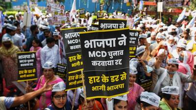 Aam Aadmi Party supporters during a protest against BJP for postponing the Municipal Corporations of Delhi (MCD) elections on March 14. AAP has maintained that the merger was just a ploy by the BJP-led central government to delay the MCD elections that were scheduled to be held in April. (HT Archive) Aam Aadmi Party supporters during a protest against BJP for postponing the Municipal Corporations of Delhi (MCD) elections on March 14. AAP has maintained that the merger was just a ploy by the BJP-led central government to delay the MCD elections that were scheduled to be held in April. (HT Archive)