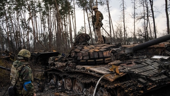 A Ukrainian soldier stands one top of a destroyed Russian tank on the outskirts of Kyiv, Ukraine. (AP Photo/Rodrigo Abd)(AP)