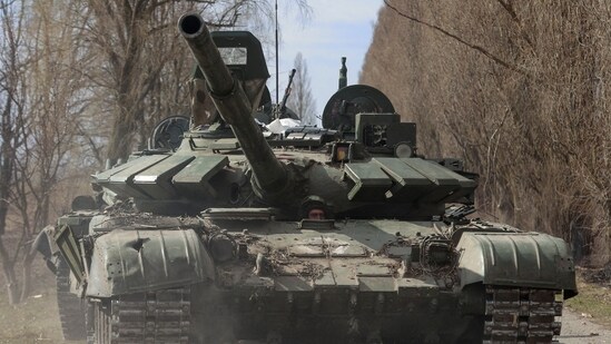 A Ukrainian service member drives a captured Russian T-72 tank, as Russia's attack continues, in the recently liberated village of Lukianivka, in Kyiv region.&nbsp;