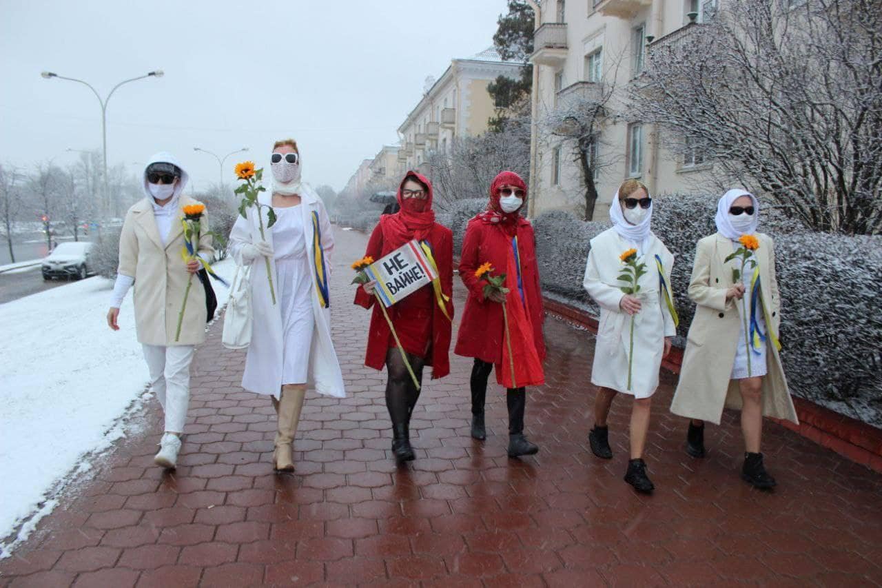 Belarusean women, dressed in the colours representing their sovereign flag, holding sunflowers and placard in support of Ukraine. &nbsp;