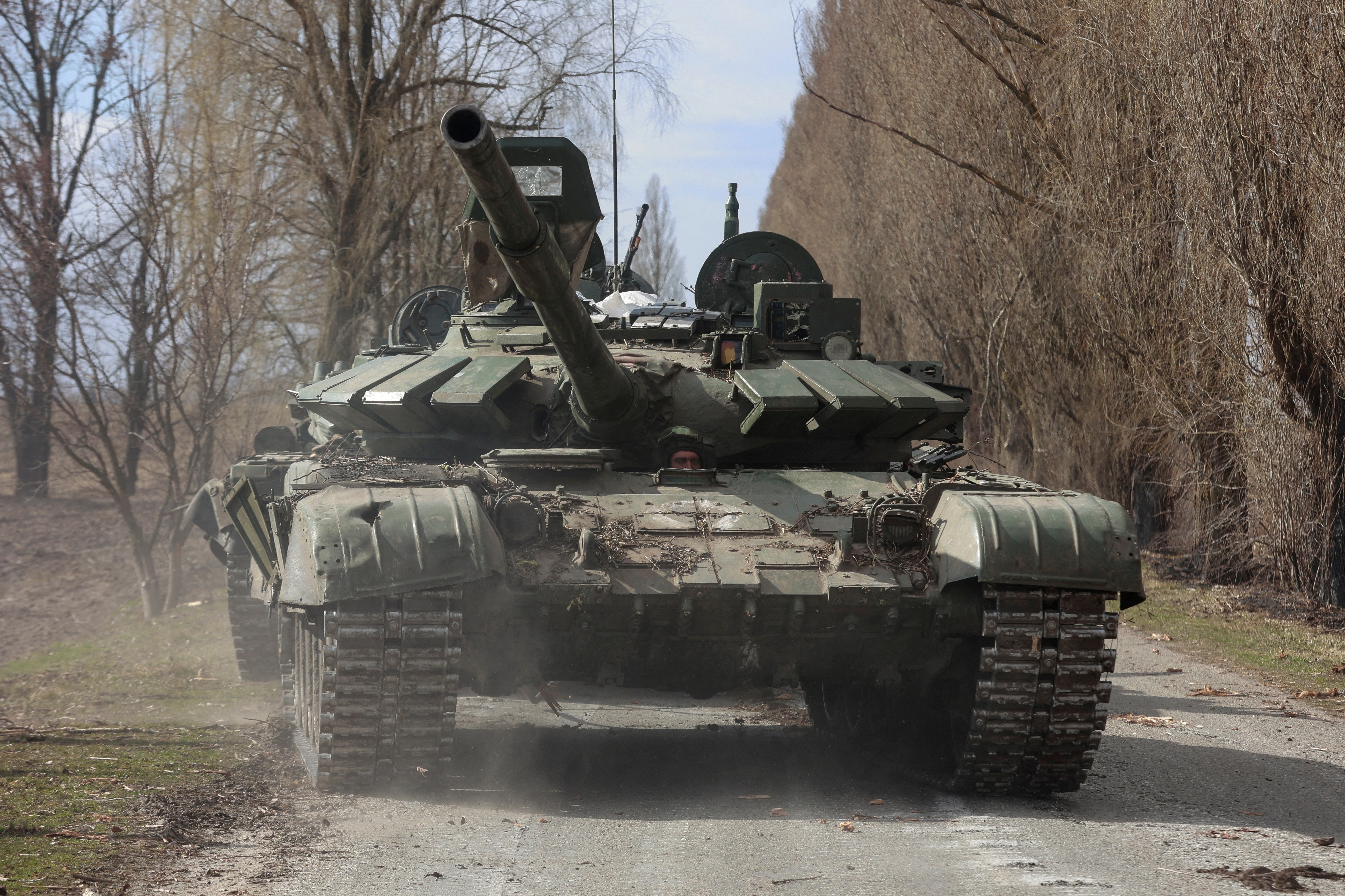 A Ukrainian service member drives a captured Russian T-72 tank, as Russia's attack continues, in the recently liberated village of Lukianivka, in Kyiv region.&nbsp; (Reuters Photo)