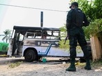 A soldier guards an area next to a burnt-out bus near the Sri Lankan president's home in Colombo on April 1, 2022.. (Photo by Ishara S. KODIKARA / AFP)(AFP) A soldier guards an area next to a burnt-out bus near the Sri Lankan president's home in Colombo on April 1, 2022.. (Photo by Ishara S. KODIKARA / AFP)(AFP)