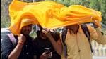 Students try to protect themselves from the scorching heat. (ANI PHOTO)