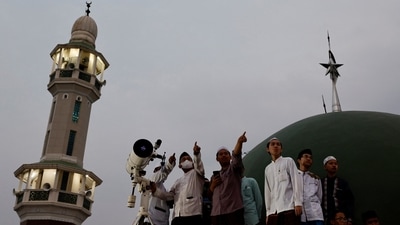 Muslim men look for the position of the moon to mark the first day of the holy fasting month of Ramadan on the roof of Al-Musyari'in mosque in Jakarta, Indonesia, April 1, 2022.&nbsp; (REUTERS/Willy Kurniawan)