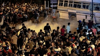 Demonstrators move away from tear gas used by the police near Sri Lankan President Gotabaya Rajapaksa's residence during a protest against him as many parts of the crisis-hit country faced up to 13 hours without electricity due to a shortage of foreign currency to import fuel, in Colombo. (REUTERS)