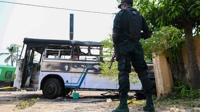A soldier guards an area next to a burnt-out bus near the Sri Lankan president's home in Colombo on April 1, 2022.. (Photo by Ishara S. KODIKARA / AFP) (AFP) A soldier guards an area next to a burnt-out bus near the Sri Lankan president's home in Colombo on April 1, 2022.. (Photo by Ishara S. KODIKARA / AFP) (AFP)