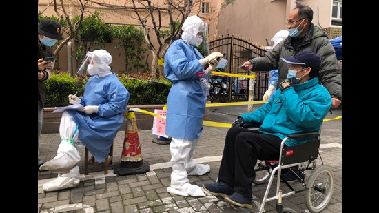 Workers in protective gear register residents for the first round of mass Covid testing in the Jingan district of western Shanghai, China, on Friday. (AP)