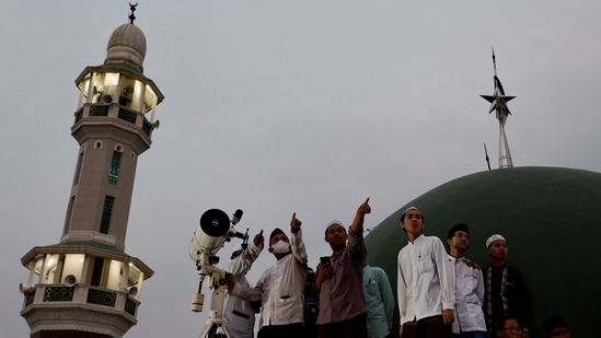 Muslim men look for the position of the moon to mark the first day of the holy fasting month of Ramadan on the roof of Al-Musyari'in mosque in Jakarta, Indonesia, April 1, 2022.&nbsp;(REUTERS/Willy Kurniawan)