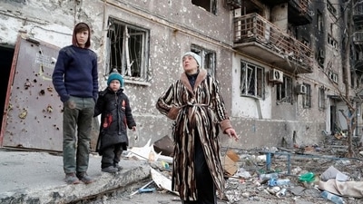 The Bykovets family members, Olga, 42, Ilya, 13, and Yegor, 5, who seek refuge in abandoned apartments of a residential building damaged in the course of Ukraine-Russia conflict, gather in a courtyard in the southern port city of Mariupol.&nbsp; (REUTERS)