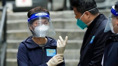 Hong Kong Chief Executive Carrie Lam, left, wears gloves before delivering package of coronavirus prevention materials to people during an anti-epidemic event in Hong Kong. (AP) Hong Kong Chief Executive Carrie Lam, left, wears gloves before delivering package of coronavirus prevention materials to people during an anti-epidemic event in Hong Kong. (AP)