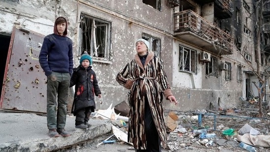 The Bykovets family members, Olga, 42, Ilya, 13, and Yegor, 5, who seek refuge in abandoned apartments of a residential building damaged in the course of Ukraine-Russia conflict, gather in a courtyard in the southern port city of Mariupol.&nbsp;(REUTERS)