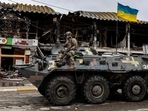 An Ukranian soldier patrols in an armoured vehicle a street in Bucha, northwest of Kyiv, on April 2, 2022, where town's mayor said 280 people had been buried in a mass grave and that the town is littered with corpses. (Photo by RONALDO SCHEMIDT/AFP)