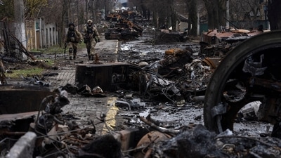Soldiers walk amid destroyed Russian tanks in Bucha, in the outskirts of Kyiv, Ukraine. Ukrainian troops are finding brutalized bodies and widespread destruction in the suburbs of Kyiv, sparking new calls for a war crimes investigation and sanctions against Russia. (AP)