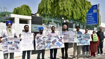 Activists protesting outside residence of corporation commissioner in Ludhiana on April 03, 2022 with posters featuring Veeru and Basanti’s dialogue from Sholey. (Harsimar Pal Singh/HT)