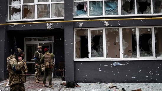 Ukranian soldiers patrol a street in Bucha, northwest of Kyiv, on April 2, 2022, where town's mayor said 280 people had been buried in a mass grave and that the town is littered with corpses.