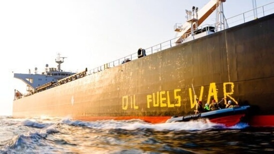 Activists of the environmental organisation Greenpeace paint the words 'Oil fuels war' on the hull of a ship carrying Russian oil near the German island Fehmarn, Germany. (Frank Molter/dpa via AP)