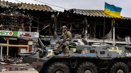 An Ukranian soldier patrols in an armoured vehicle a street in Bucha, northwest of Kyiv, on April 2, 2022, where town's mayor said 280 people had been buried in a mass grave and that the town is littered with corpses. (Photo by RONALDO SCHEMIDT/AFP)