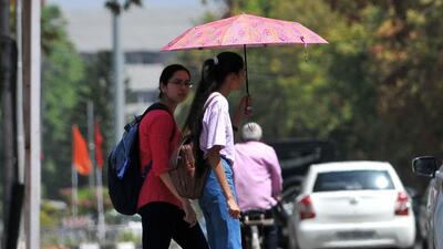 Students taking cover under an umbrella on a sweltering Monday on the Panjab University campus in Chandigarh. (Ravi Kumar/HT)