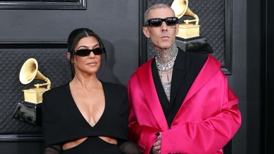 Kourtney Kardashian and Travis Barker attended the Grammys in coordinated black ensembles. While Kourtney chose an Et Ochs jumpsuit, Travis wore a Givenchy suit with a fuchsia pink overcoat. (REUTERS)