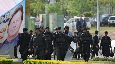 Security personnel walk past a banner featuring an image of Pakistan's Prime Minister Imran Khan near Parliament in Islamabad. (AFP) Security personnel walk past a banner featuring an image of Pakistan's Prime Minister Imran Khan near Parliament in Islamabad. (AFP)