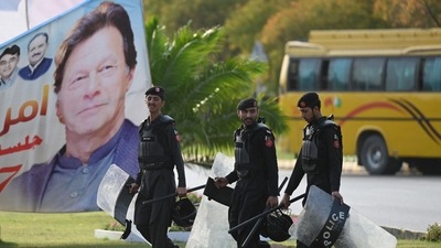 Security personnel walk past a banner featuring an image of Pakistan's Prime Minister Imran Khan near Parliament House building in Islamabad (AFP) Security personnel walk past a banner featuring an image of Pakistan's Prime Minister Imran Khan near Parliament House building in Islamabad (AFP)