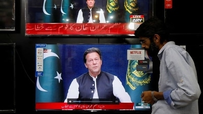 A shopkeeper tunes a television screen to watch the speech of Pakistani Prime Minister Imran Khan, at his shop in Islamabad,&nbsp; (REUTERS)